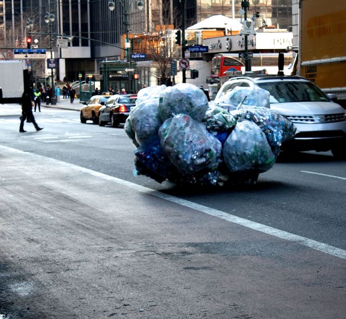 new york city 7th avenue person taking cans and bottles up the street