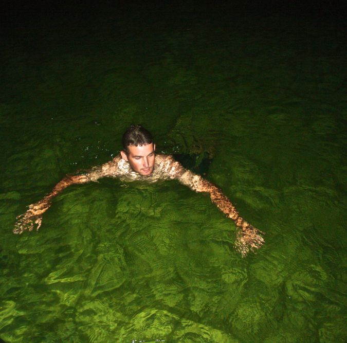 cayman islands boat guide swimming in green water